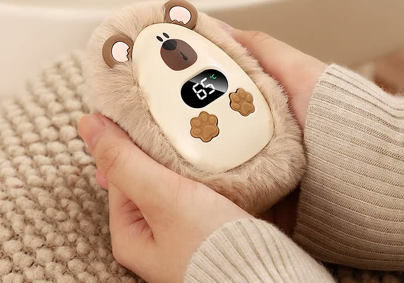Calentador de manos CozyPuff de peluche sujetado entre las dos manos
