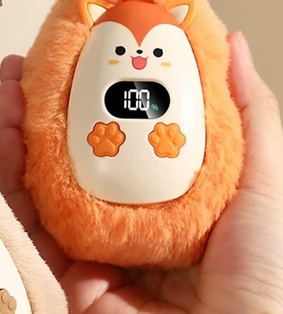 Calentador de manos CozyPuff modelo zorro naranja sujetado en la mano